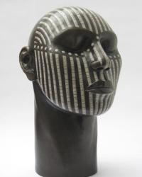 Raku fired tribal head with a design in white crackled lines and dots