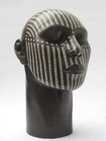 Raku fired tribal head with a design in white crackled lines and dots